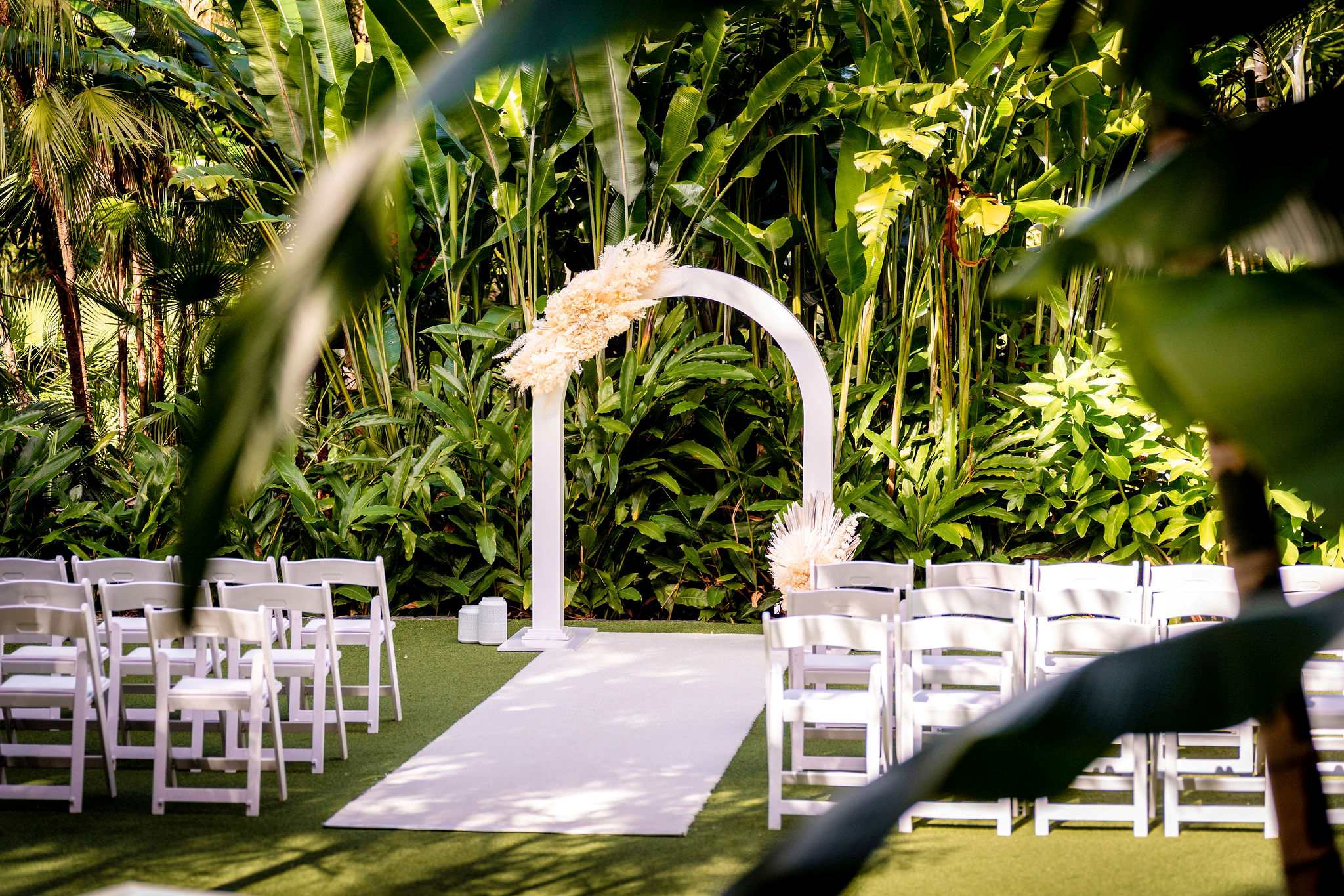 White dried flowers on curved wedding arch